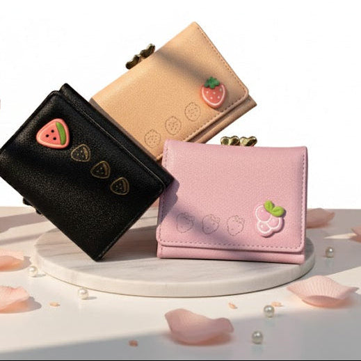 Three small wallets in black, beige, and pink